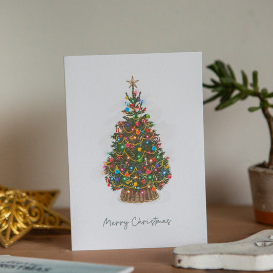 Christmas card with a decorated tree design on a table.