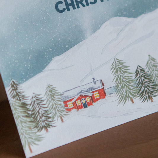 Christmas card with a snowy landscape and red cabin